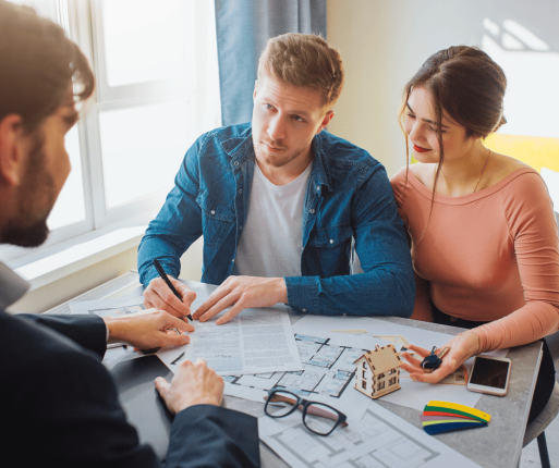 Couple rencontrant un professionnel pour comprendre les frais à prévoir lors de l’achat d’une propriété au Québec.